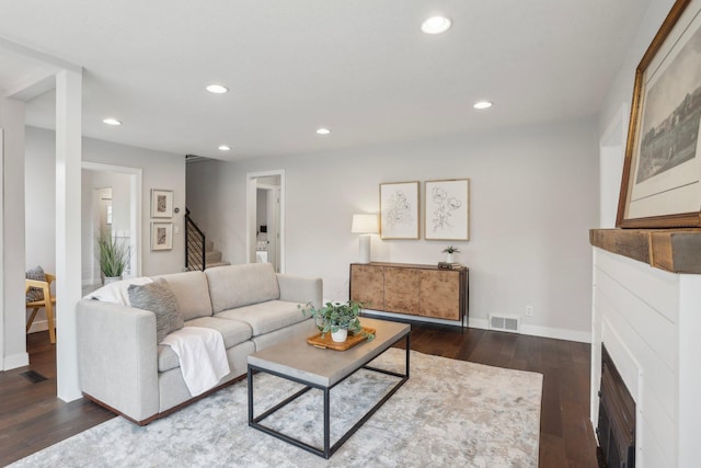 living area with stairs, recessed lighting, visible vents, and dark wood finished floors