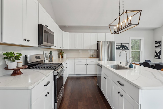 kitchen with light stone counters, a sink, dark wood finished floors, and stainless steel appliances
