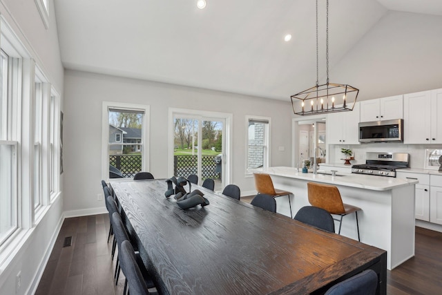 dining area with recessed lighting, dark wood-style floors, a chandelier, and a wealth of natural light