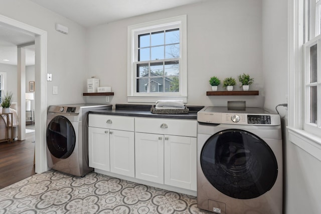 clothes washing area featuring washing machine and dryer and cabinet space