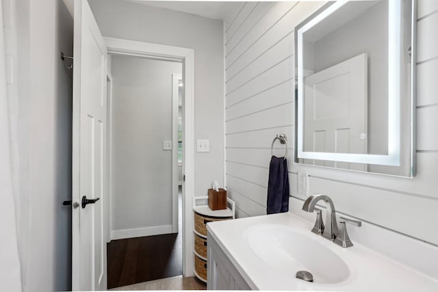bathroom featuring wood walls and vanity