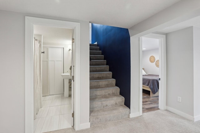 staircase featuring carpet floors and baseboards