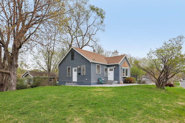 back of property featuring a yard, a chimney, and entry steps