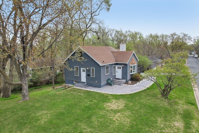 exterior space featuring a lawn, roof with shingles, and a chimney