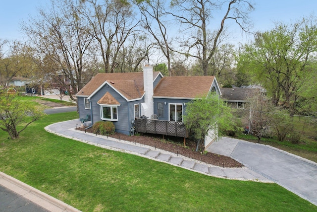 ranch-style home featuring a chimney, a front lawn, and aphalt driveway
