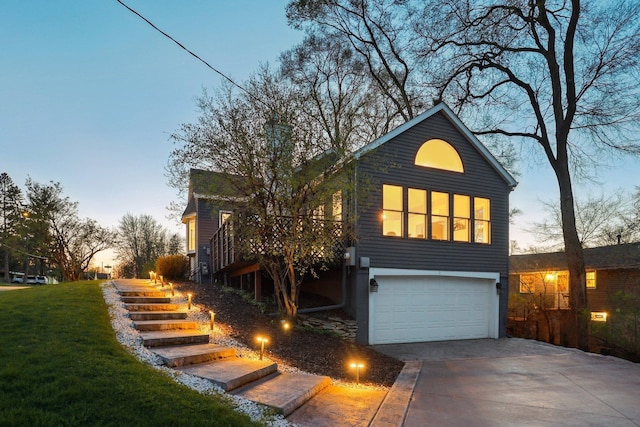 view of front of property featuring an attached garage, a lawn, driveway, and stairway
