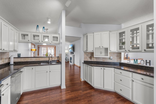 kitchen with stainless steel dishwasher, dark wood-style floors, a sink, and backsplash