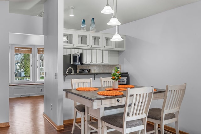 dining area featuring baseboards, dark wood-style flooring, and visible vents