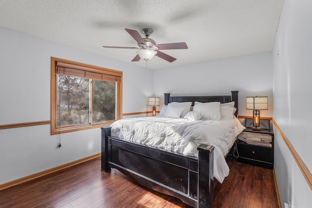 bedroom featuring baseboards, a ceiling fan, wood finished floors, and a textured ceiling