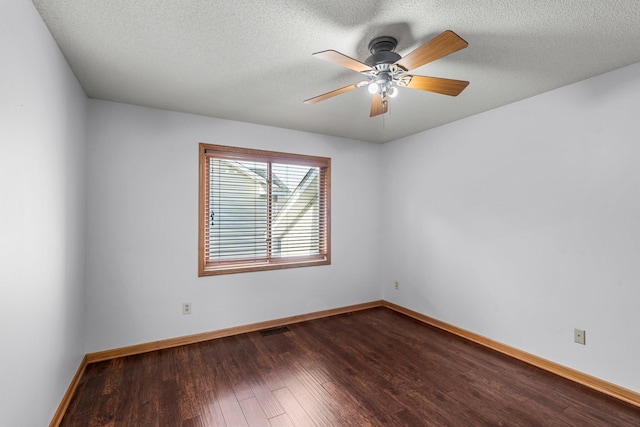 unfurnished room with ceiling fan, baseboards, dark wood-type flooring, and visible vents