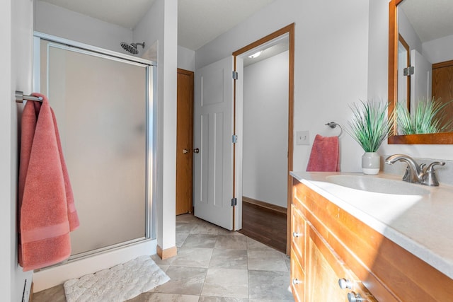 bathroom with baseboards, vanity, and a stall shower