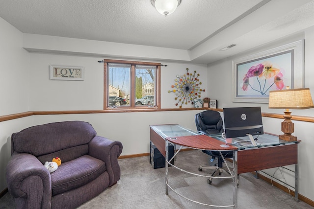 carpeted office space with visible vents, baseboards, and a textured ceiling