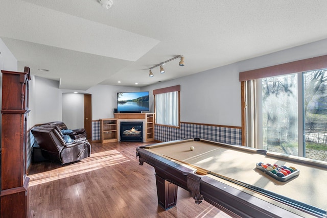 rec room featuring wainscoting, a wealth of natural light, and rail lighting