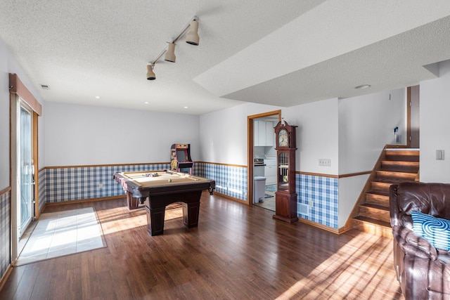 recreation room featuring wood finished floors, rail lighting, a wainscoted wall, and baseboards