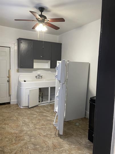 kitchen featuring ceiling fan, black electric range, and freestanding refrigerator