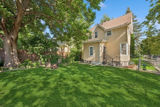 742 Laurel Ave, Saint Paul, MN 55104 - back of property with an outdoor fire pit and roof with shingles
