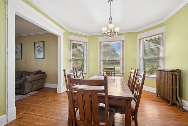 742 Laurel Ave, Saint Paul, MN 55104 - dining area with a chandelier, radiator, crown molding, and wood finished floors
