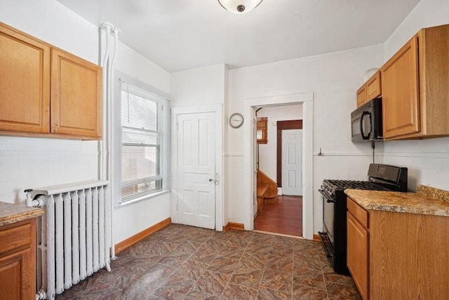 742 Laurel Ave, Saint Paul, MN 55104 - kitchen featuring black appliances, radiator, and stone finish flooring
