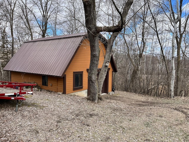 exterior space featuring a barn and metal roof