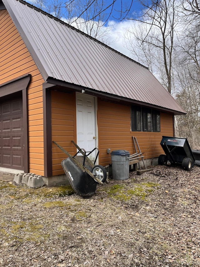 exterior space with a garage and metal roof