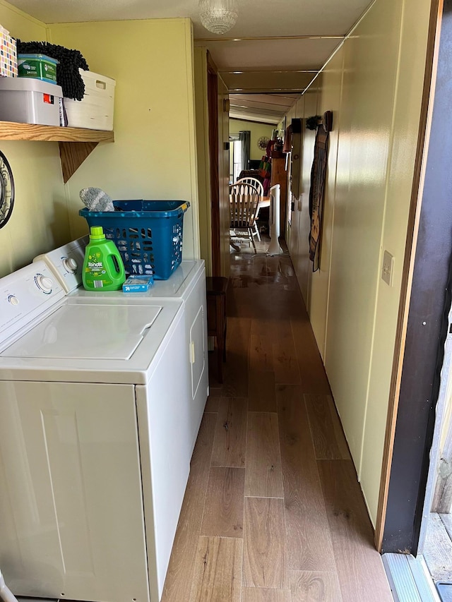 washroom featuring separate washer and dryer, laundry area, and wood finished floors