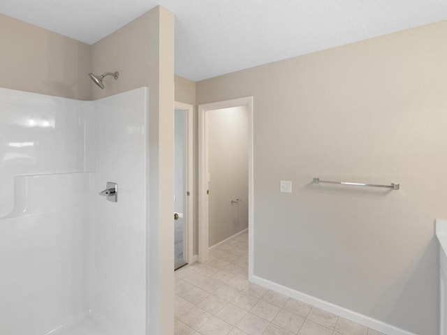 bathroom featuring a shower, baseboards, and tile patterned floors