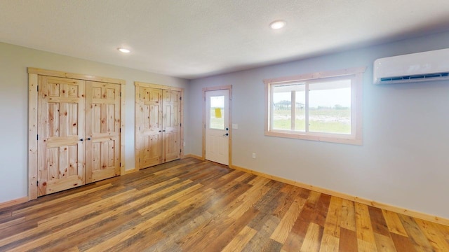 1950 228th Ln W, Mora, MN 55051 - foyer entrance featuring a wall unit AC, wood finished floors, baseboards, and recessed lighting