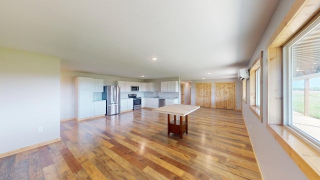 1950 228th Ln W, Mora, MN 55051 - rec room with a wall mounted AC, light wood-style floors, a sink, recessed lighting, and baseboards