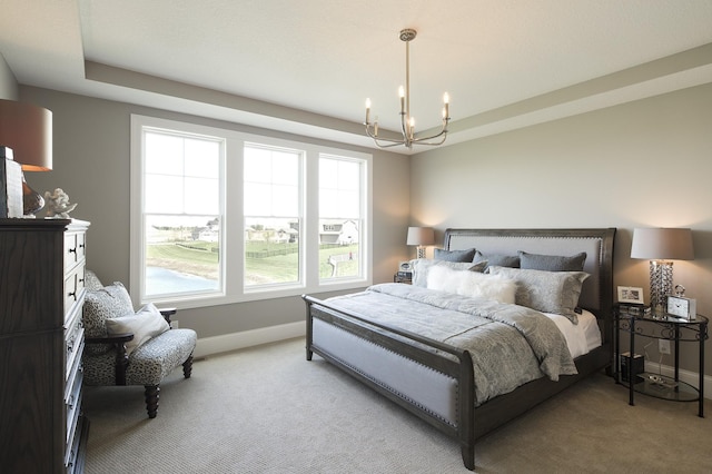 bedroom featuring light carpet, a notable chandelier, a tray ceiling, and baseboards