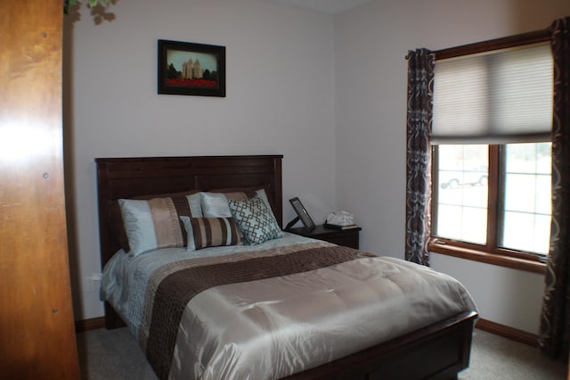bedroom with baseboards and light colored carpet