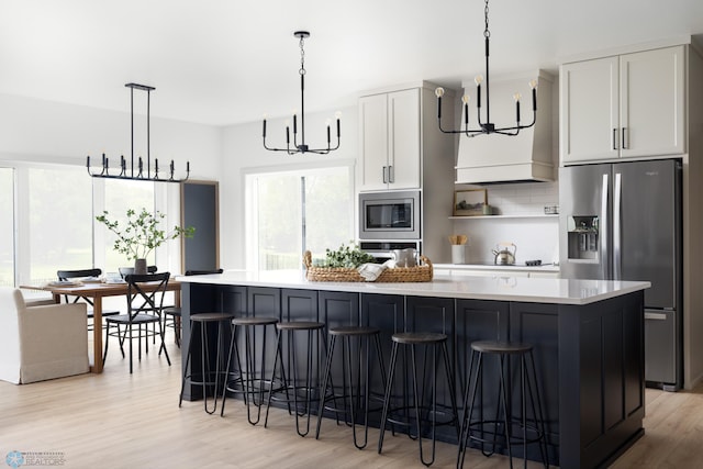 8851 Northern Lights Ave, Horace, ND 58047 - kitchen with a large island, an inviting chandelier, decorative backsplash, light countertops, and appliances with stainless steel finishes