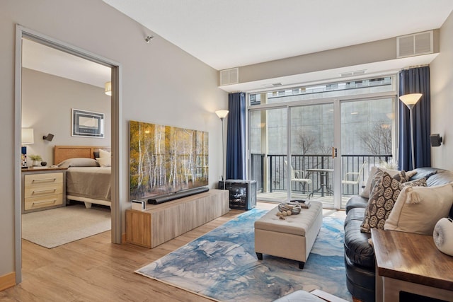 living area featuring visible vents and wood finished floors