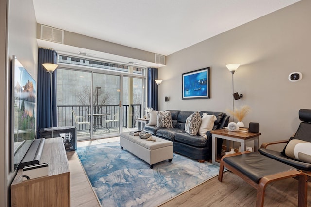 living area with visible vents and wood finished floors
