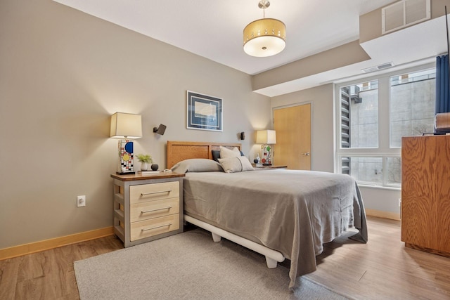 bedroom featuring baseboards, visible vents, and light wood-style flooring
