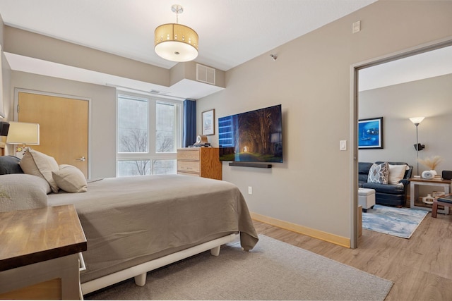 bedroom featuring baseboards, visible vents, and light wood-style flooring