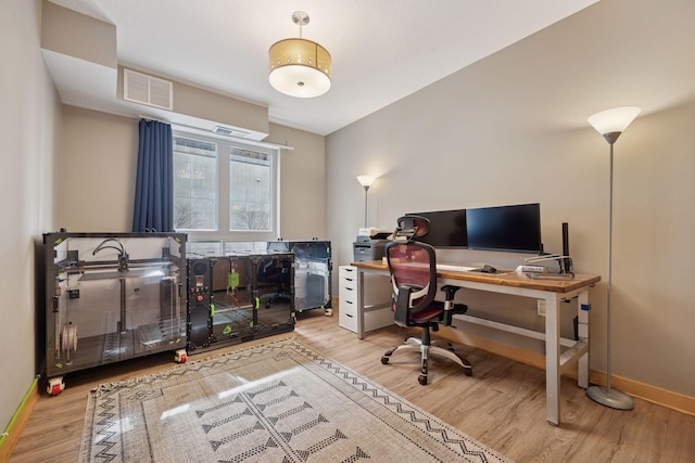 office area featuring wood finished floors, visible vents, and baseboards