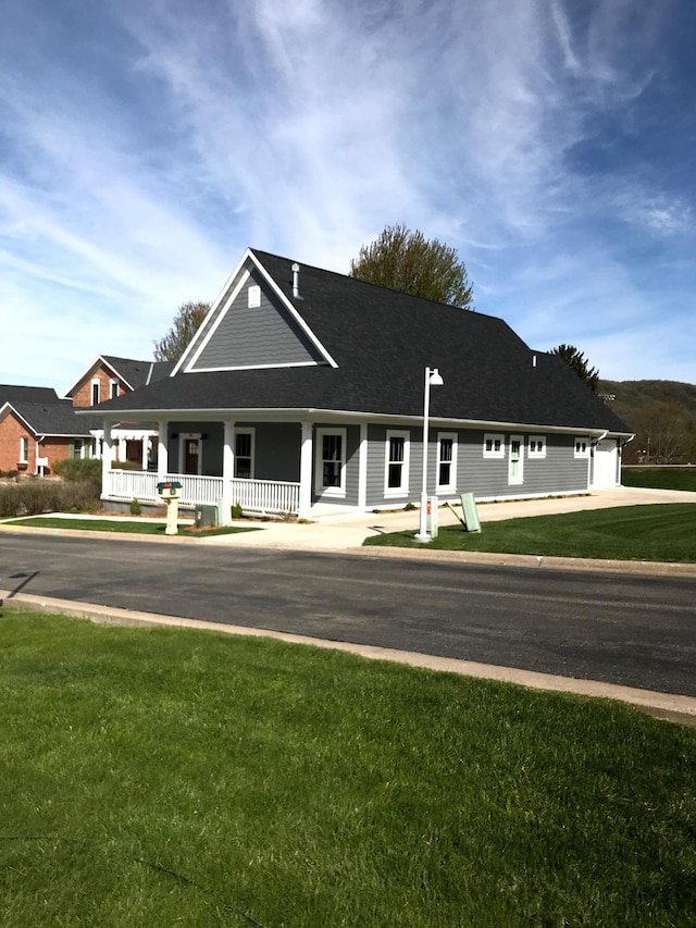 country-style home featuring covered porch and a front yard