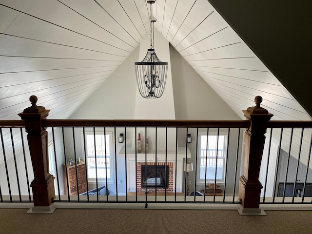 interior details featuring a notable chandelier, carpet floors, and a brick fireplace