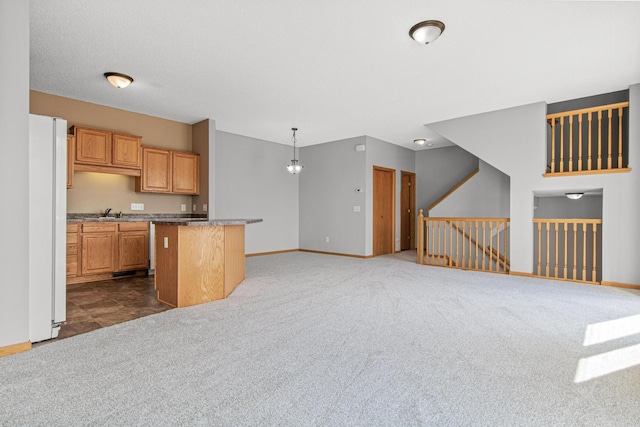 kitchen with open floor plan, dark colored carpet, baseboards, and a kitchen island