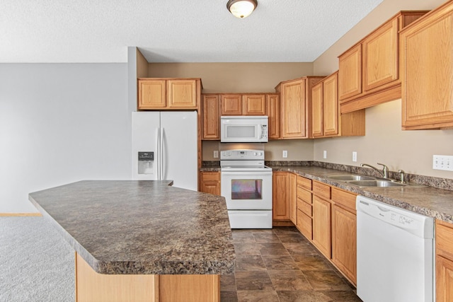 kitchen featuring a center island, dark countertops, a sink, a textured ceiling, and white appliances