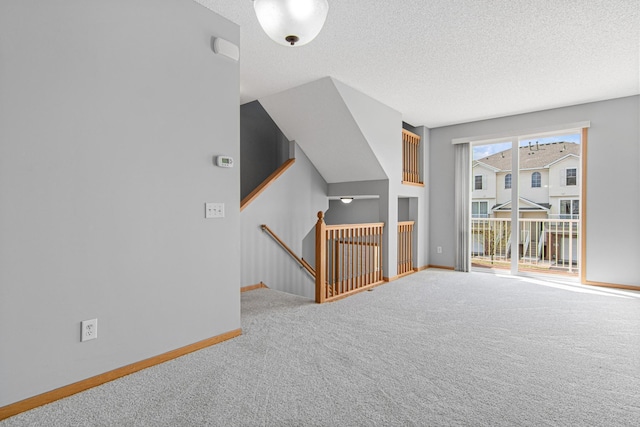 interior space featuring baseboards, carpet flooring, and a textured ceiling