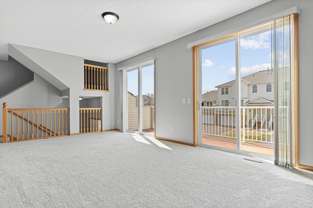 unfurnished living room with carpet floors and baseboards