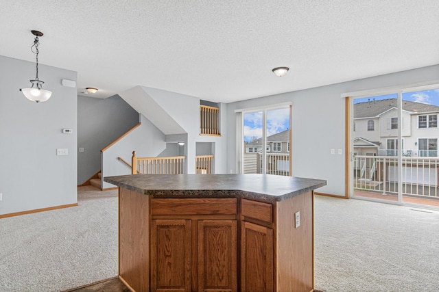 kitchen with light carpet, a textured ceiling, dark countertops, and a healthy amount of sunlight