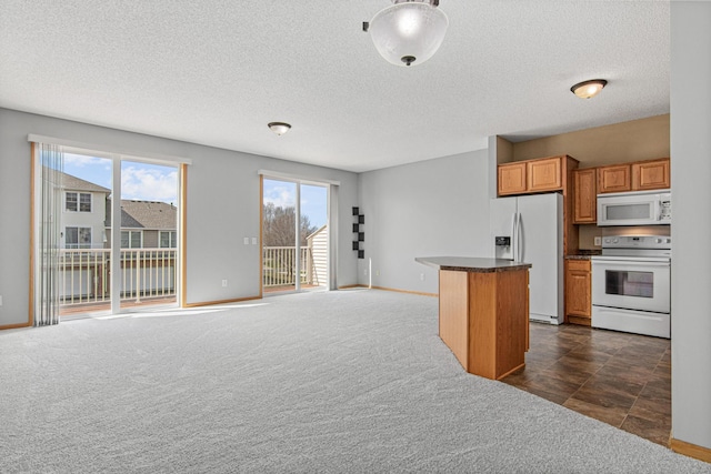 kitchen with dark countertops, dark colored carpet, white appliances, baseboards, and a textured ceiling