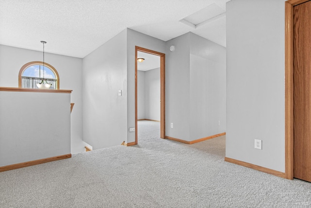 empty room featuring carpet floors, a textured ceiling, and baseboards