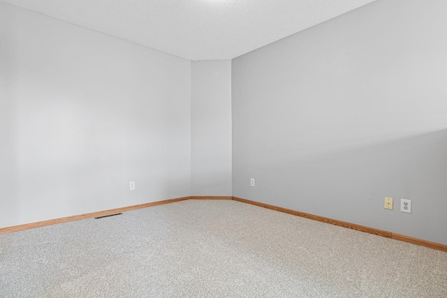 unfurnished room featuring baseboards, visible vents, and carpet
