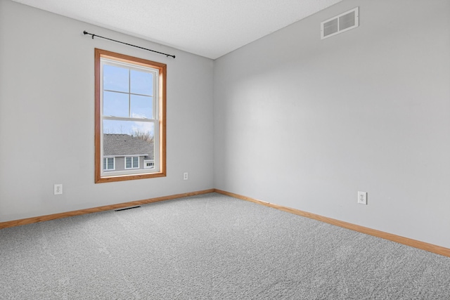 carpeted empty room with visible vents and baseboards