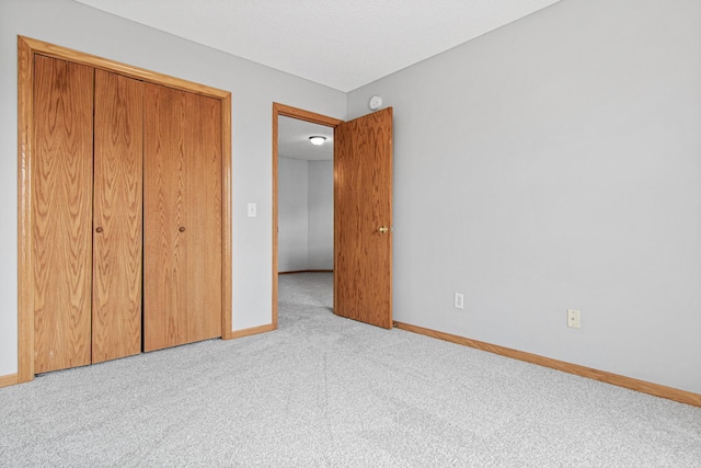 unfurnished bedroom featuring a closet, carpet flooring, and baseboards