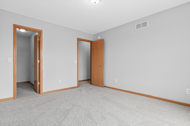 unfurnished bedroom featuring baseboards, visible vents, and carpet floors