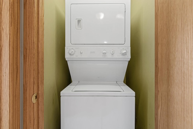 clothes washing area with stacked washer and dryer and laundry area